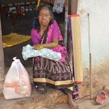 Disabled, aged grand mother with distributed Grocery food items, Blanket & Mat in front of her house